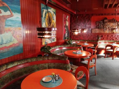 a restaurant with red walls and tables and chairs at Hotel Seltenriegel in Wies