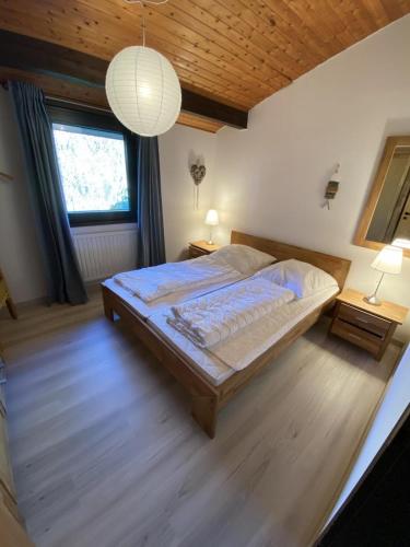 a bedroom with a large bed and a large window at Haus H7 in Großwürden