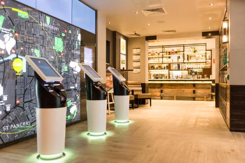 a room with three smart phones on display in a restaurant at hub London - King's Cross in London
