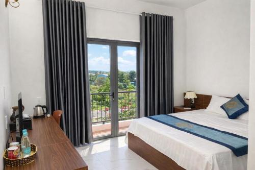 a bedroom with a bed and a large window at Đức Lưu Quang Hotel Bình Thuận in Tuy Phong