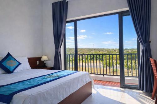 a bedroom with a bed and a large window at Đức Lưu Quang Hotel Bình Thuận in Tuy Phong