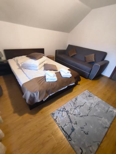 a bedroom with a large bed and a couch at Casa Georgeta in Câmpulung Moldovenesc