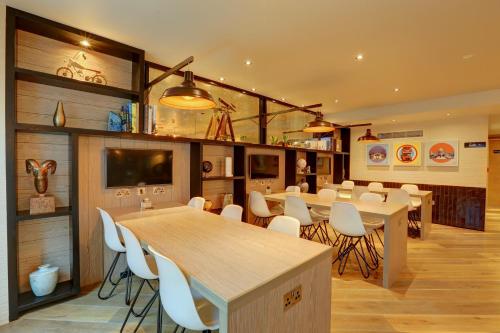 a dining room with tables and white chairs at hub London Tottenham Court Road - Goodge Street in London