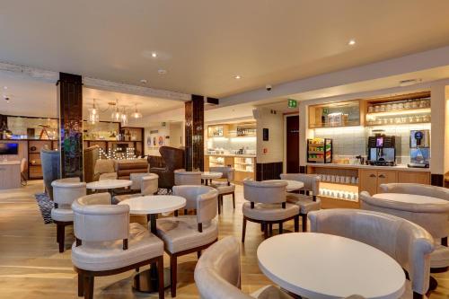a restaurant with tables and chairs and a bar at hub London Tottenham Court Road - Goodge Street in London