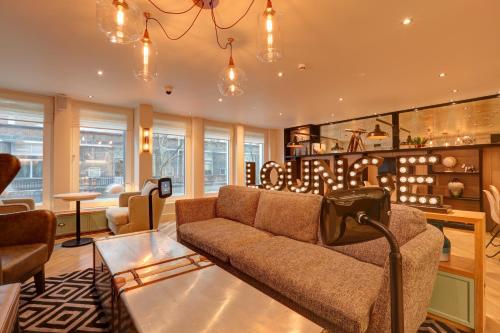 a living room with a couch and a table at hub London Tottenham Court Road - Goodge Street in London