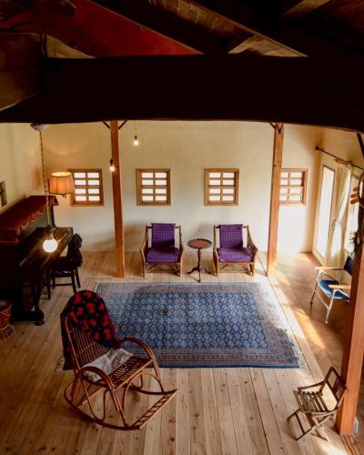 a living room with chairs and a rug at Hotel Namaskar in Naka-yamada