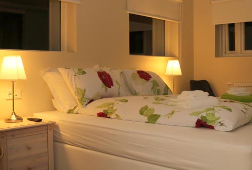 uma cama com lençóis brancos e flores vermelhas em 1A Guesthouse em Vatnsholt
