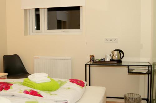 um quarto com uma mesa e uma toalha verde numa cama em 1A Guesthouse em Vatnsholt