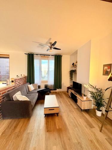 a living room with a couch and a table at Bright loft-style duplex 6 people Dunkirk in Coudekerque-Branche