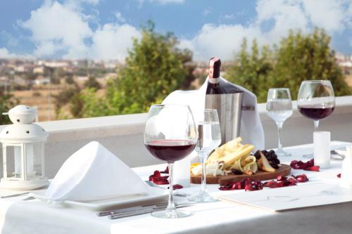 a table with wine glasses and a bottle of wine at Casa Bianca Hotel in Denizli