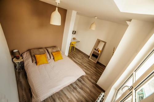 a bedroom with a bed with yellow pillows at Le Millésime in Chalons en Champagne