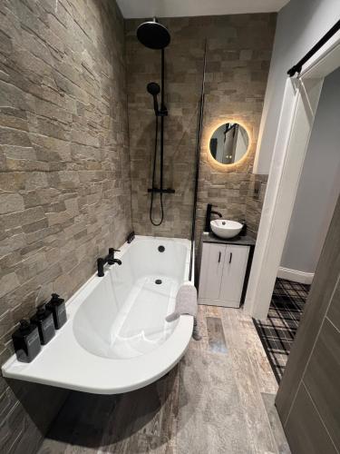 a white bath tub in a bathroom with a sink at Longshore Drift in Woodhorn