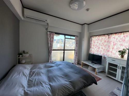 a bedroom with a large bed and a window at Peace Wing 6D in Kami-nagarekawachō