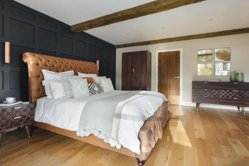 a bedroom with a large bed with a wooden headboard at 1 Force Mill Barn - Ridgestone in Ulverston