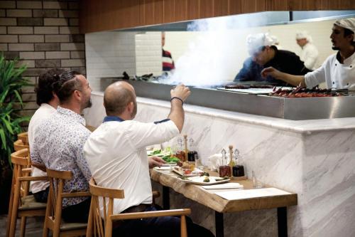 a group of people sitting at a table ordering food at Casa Bianca Hotel in Denizli