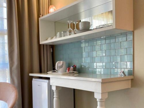a kitchen with a counter with blue tile on the wall at The Ranch Guesthouse in Potchefstroom