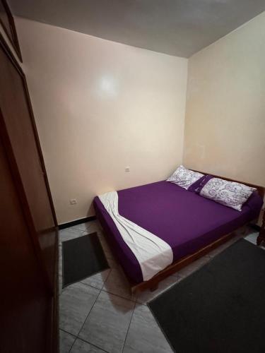 a small bed in a room with purple sheets at Tamraght Waves Retreat 2 in Tamraght Ouzdar