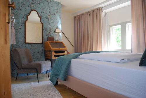 a bedroom with a bed and a desk and a chair at Tauber Lodge in Creglingen