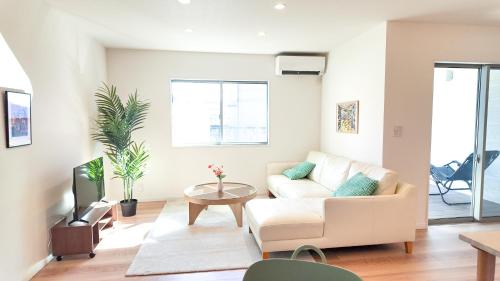 a living room with a couch and a table at 9Stay伊勢崎 in Isesaki