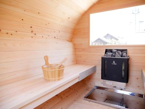 a sauna with a wooden tub and a stove at 9Stay伊勢崎 in Isesaki