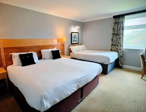 a hotel room with two beds and a window at Apollo Hotel in Basingstoke