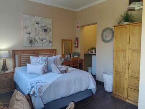 a bedroom with a large bed with blue pillows at Acacia Gastehuis in Kathu