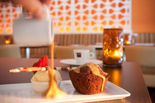 a plate with a muffin and ice cream on a table at PARKROYAL Parramatta in Sydney