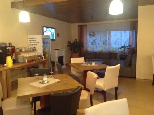 a restaurant with tables and chairs and a living room at Hotel M&S garni in Donauwörth