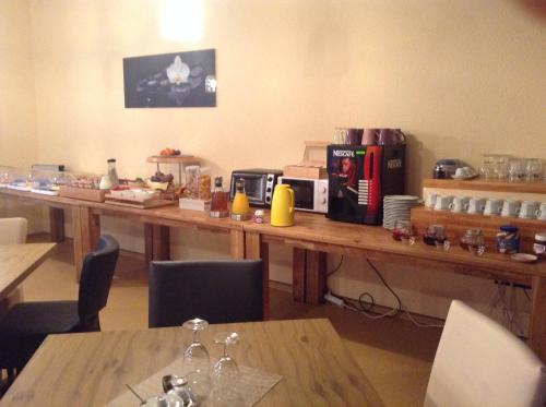 a long wooden table with a coffee maker on it at Hotel M&S garni in Donauwörth