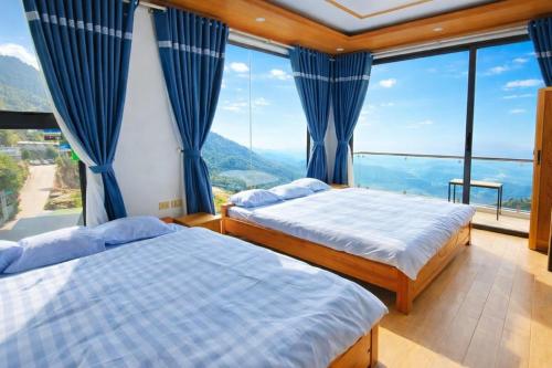 two beds in a room with a large window at Daisy Hotel Tam Dao in Tam Ðảo