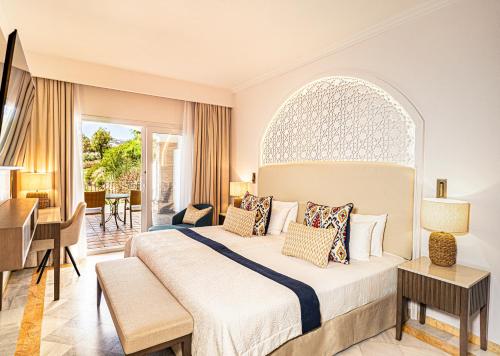 a hotel room with a bed and a desk at La Cala Resort in La Cala de Mijas