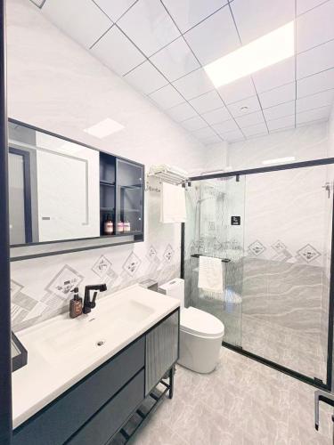 a bathroom with a toilet and a sink and a shower at Xiaos Henderson Hotel in Lungga