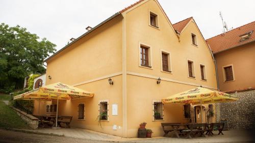 two tables and umbrellas in front of a building at Penzion Zatisi in Mikulov