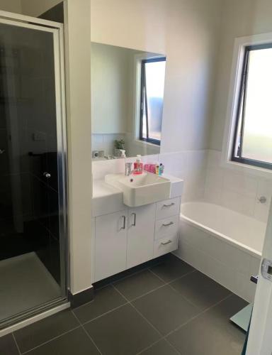 a white bathroom with a sink and a shower at BrinCole - Pet-Friendly, Huge Deck with Epic Views & Fire Pit in Bonnie Doon