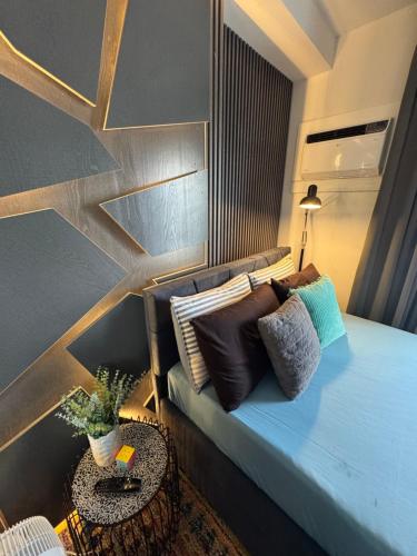 a bedroom with a bed with pillows on it at Studio McBi in Davao City