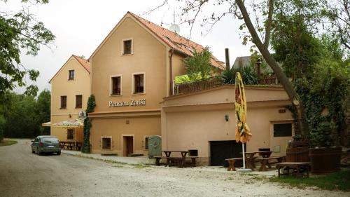 a building with benches and tables in front of it at Penzion Zatisi in Mikulov