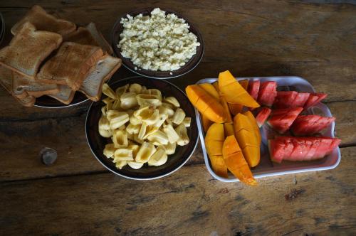 three bowls of food with fruit and other ingredients on a table at White Sands in Paje