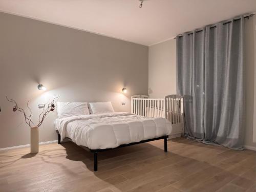 a white bedroom with a bed and a window at Elisir in Bergamo