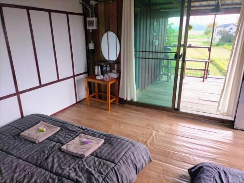 a bedroom with a bed with two towels on it at Ricefield Homestay มองนาภูคาน่านโฮมสเตย์ in Ban Thon (1)