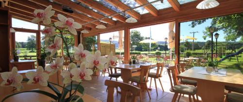 a restaurant with tables and chairs and windows at Gasthof Lamprecht in Peiting