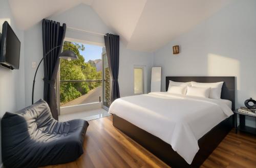 a bedroom with a large white bed and a window at 2Bi s Home Dalat 3 in Da Lat