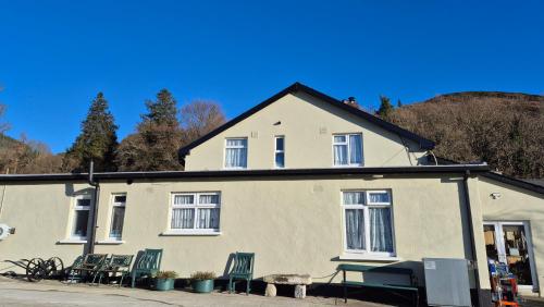 una casa con sedie e un tavolo davanti di Coolalingo B&B a Drumgoff Bridge