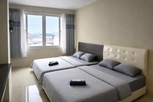 two beds in a hotel room with two bedsitures at SleepRest @ NTC in Nagoya