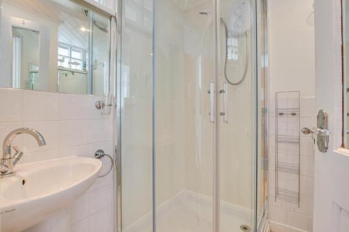 a white bathroom with a shower and a sink at 1 Bed in St Ives oc-crab02 in St Ives