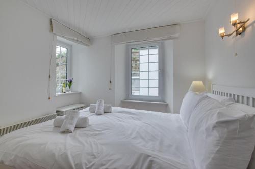 a white bedroom with a large white bed with towels on it at 1 Bed in St Ives oc-crab02 in St Ives
