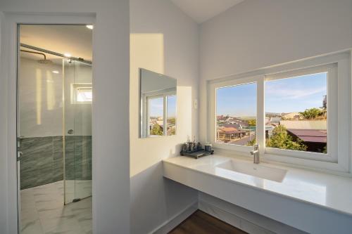 a white bathroom with a sink and a window at 2Bi s Home Dalat 3 in Da Lat
