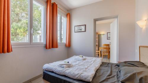 a bedroom with a bed and two windows at L Ocean N11 2P4 in La Tranche-sur-Mer