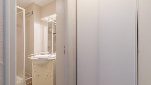 a white bathroom with a sink and a mirror at L Ocean N11 2P4 in La Tranche-sur-Mer