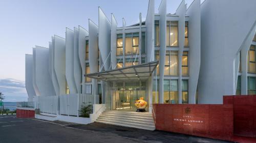 a man is standing in front of a building at Orient Luxury Hotel Kenting in Hengchun South Gate