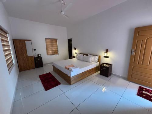 a white bedroom with a bed and a door at Tranquil Waves Marari in Mararikulam